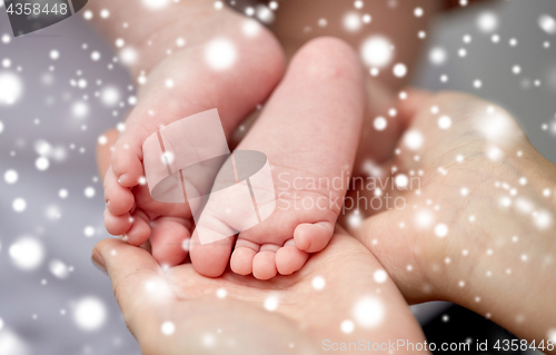 Image of close up of newborn baby feet in mother hands