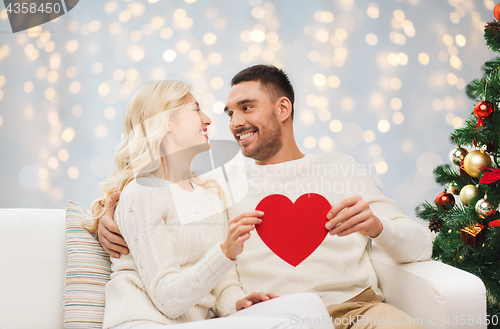 Image of happy couple with red heart at christmas