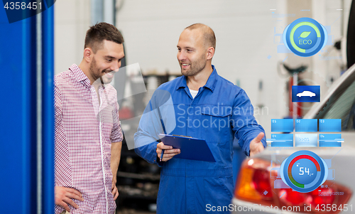 Image of auto mechanic with clipboard and man at car shop