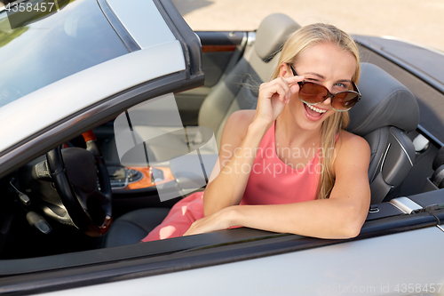 Image of happy young woman in convertible car