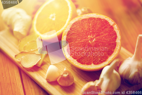 Image of grapefruit, ginger, garlic and orange on board