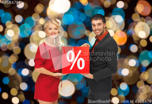 Image of couple with discount sign over christmas lights