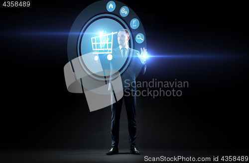 Image of businessman with shopping cart on virtual screen