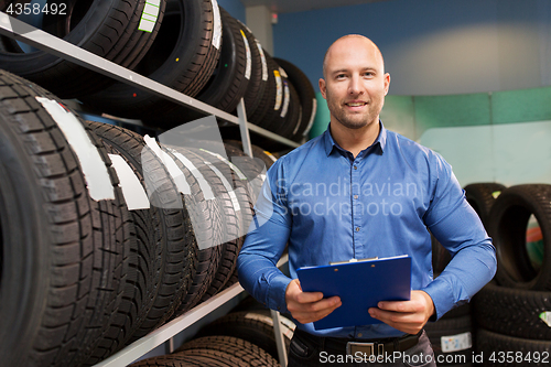 Image of auto business owner and wheel tires at car service