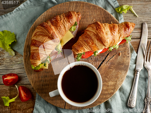 Image of two croissant sandwiches on wooden table