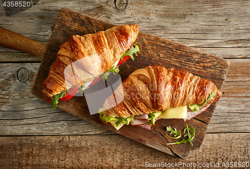 Image of two croissant sandwiches on wooden table