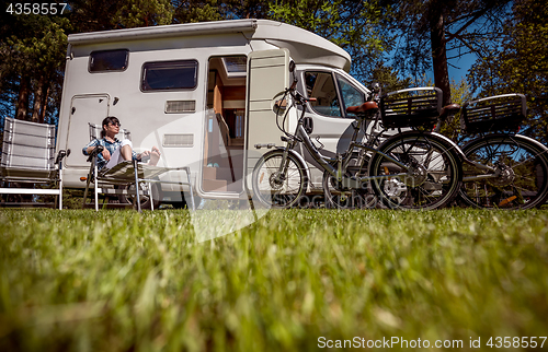 Image of Woman resting near motorhomes in nature. Family vacation travel,