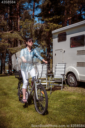 Image of Woman on electric bike resting at the campsite VR Caravan car Va