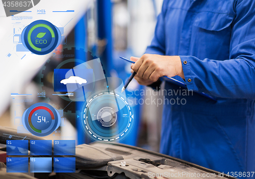 Image of auto mechanic man with clipboard at car workshop