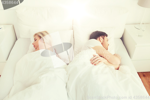 Image of couple sleeping in bed at home