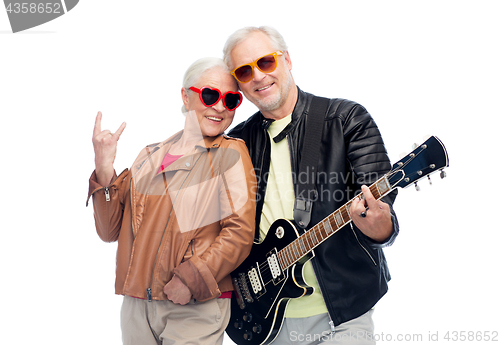 Image of senior couple with guitar showing rock hand sign