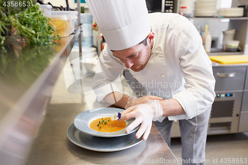 Image of happy male chef cooking food at restaurant kitchen