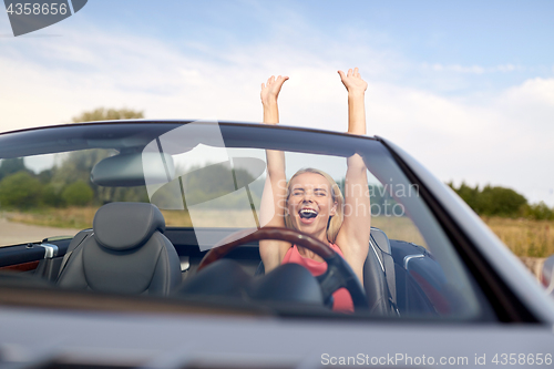 Image of happy young woman in convertible car