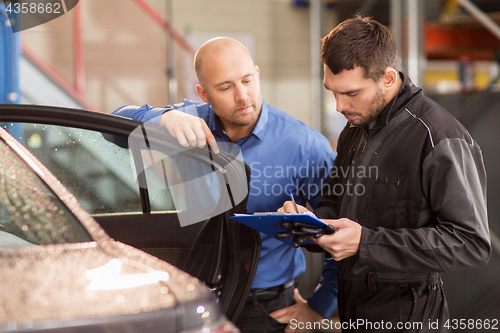 Image of auto mechanic and customer at car shop