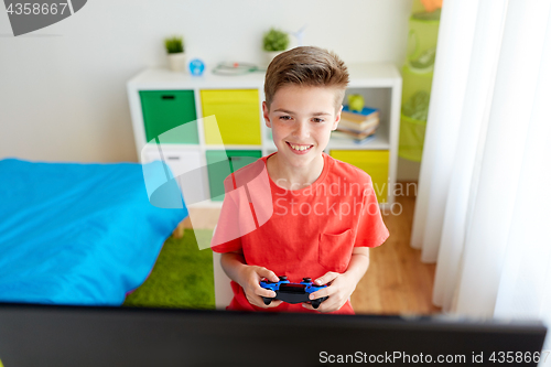 Image of boy with gamepad playing video game on computer