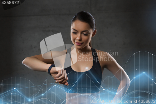 Image of young woman with heart-rate watch in gym