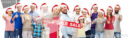 Image of people in santa hats with sale sign at christmas