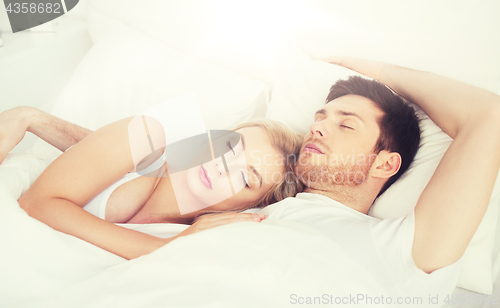 Image of happy couple sleeping in bed at home