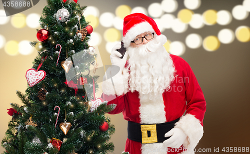 Image of santa claus calling on smartphone at christmas