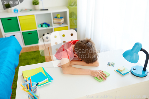 Image of tired or sad student boy with smartphone at home