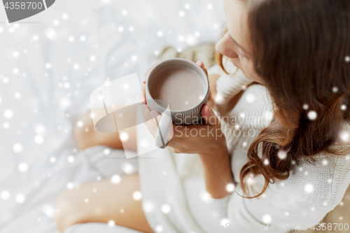 Image of close up of woman with cocoa cup in bed at home