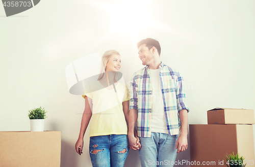 Image of smiling couple with big boxes moving to new home