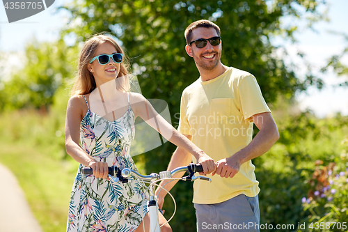 Image of happy couple with bicycle at country