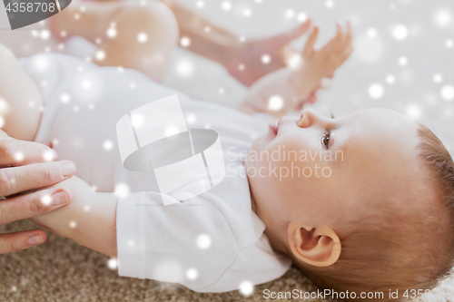 Image of close up of happy little baby and mother hands