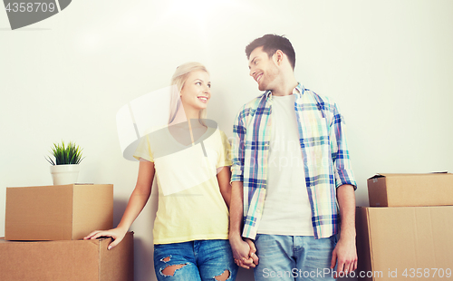 Image of smiling couple with big boxes moving to new home