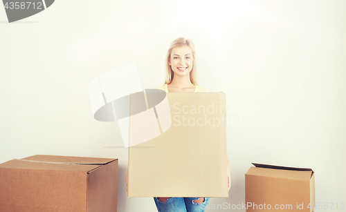 Image of smiling young woman with cardboard box at home