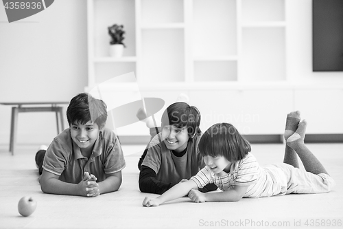 Image of boys having fun with an apple on the floor