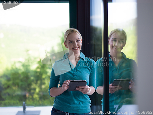 Image of young women using tablet computer by the window