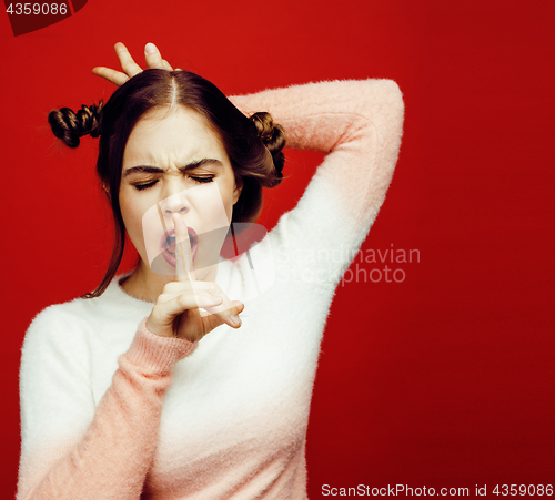 Image of young pretty emitonal posing teenage girl on bright red background, happy smiling lifestyle people concept 