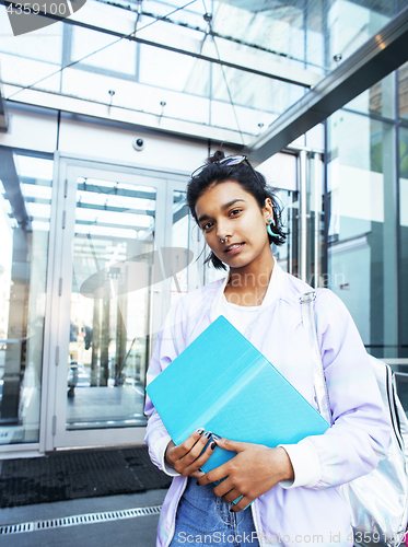 Image of young cute indian girl at university building sitting on stairs 