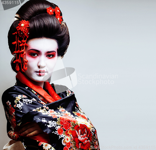 Image of young pretty geisha in kimono with sakura and red decoration des