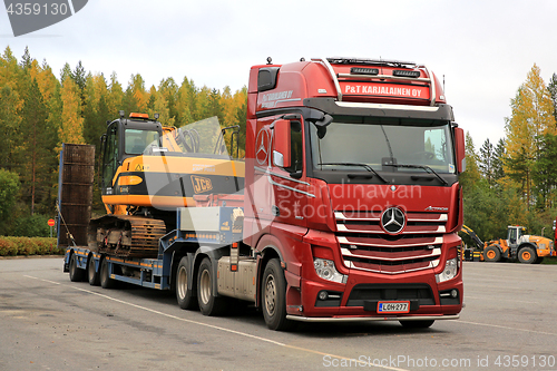 Image of Red Mercedes-Benz Actros Hauls JCB Excavator on Trailer