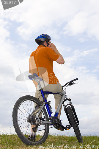 Image of Man with bicycle making a phone call