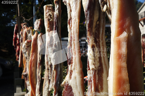 Image of The suspended pieces of the meat drying outside