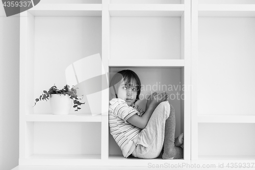 Image of young boy posing on a shelf