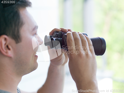 Image of man looking with binoculars