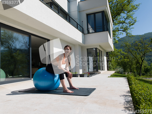 Image of woman doing exercise with pilates ball