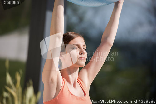 Image of woman doing exercise with pilates ball