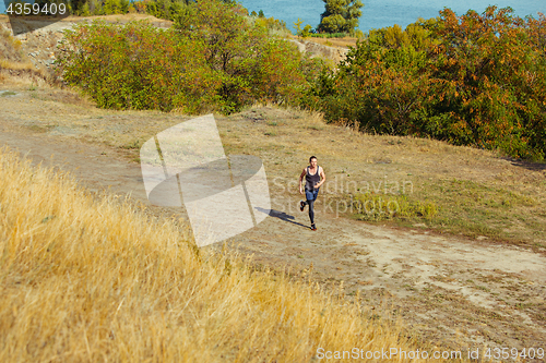 Image of Running sport. Man runner sprinting outdoor in scenic nature. Fit muscular male athlete training trail running for marathon run.