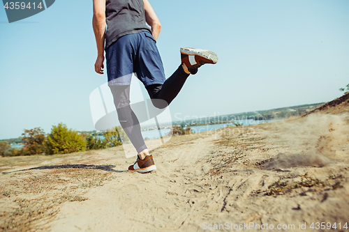 Image of Running sport. Man runner sprinting outdoor in scenic nature. Fit muscular male athlete training trail running for marathon run.