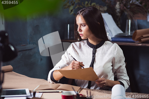 Image of Young beautiful woman working with laptop