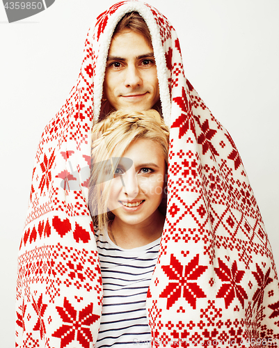 Image of young pretty teenage couple at Christmas time warming in red decorated blanket, hipster guy with his girlfriend happy smiling and hugging isolated on white background, lifestyle people concept 