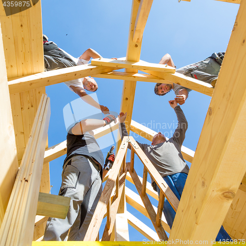 Image of Builders at work with wooden roof construction.