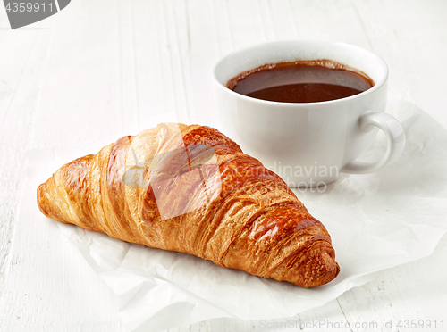 Image of freshly baked croissant and coffee cup