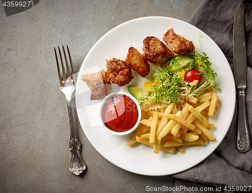 Image of Plate of fried potatoes and pork kebab