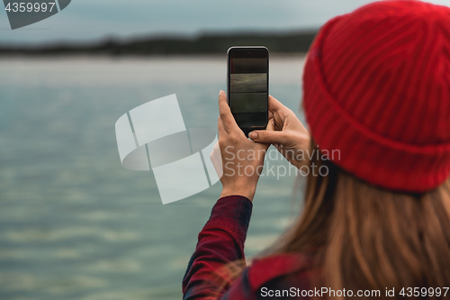 Image of Woman taking pictures with a cellphone